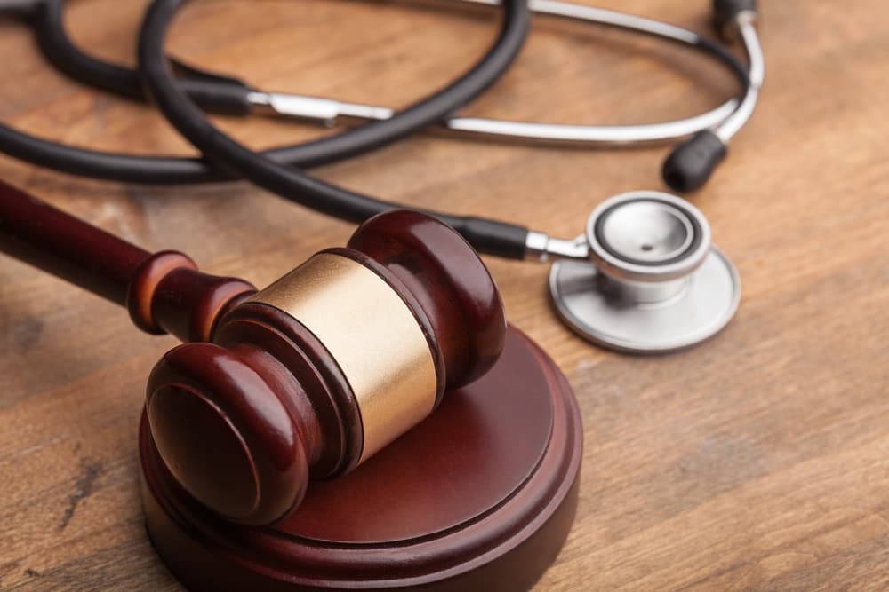 A wooden gavel and a stethoscope on a table.
